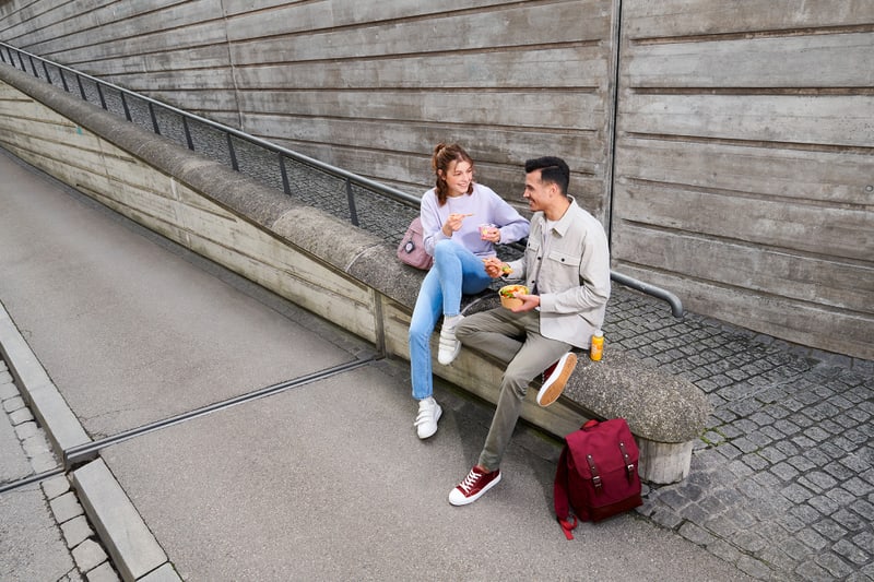 Zwei Personen sitzen an der Strasse