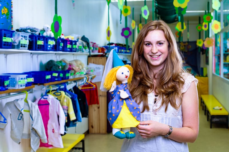 Un'apprendista operatrice socioassistenziale assistenza all’infanzia mostra delle marionette da dito