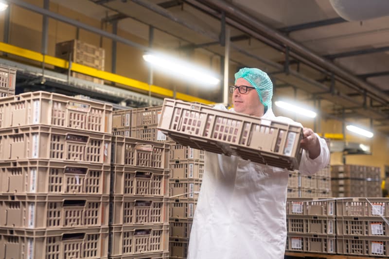 Mitarbeiter mit Gebinde in der Hand