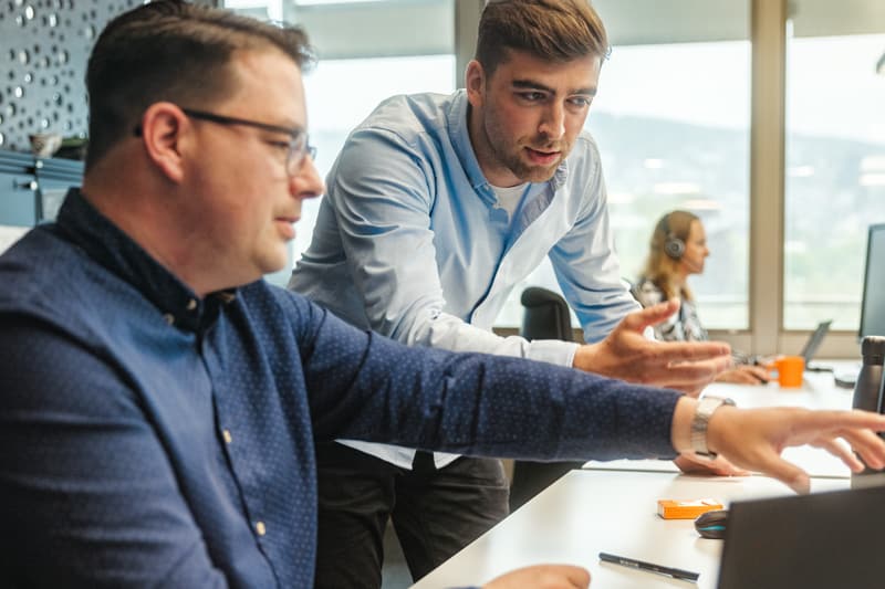 Zwei Personen besprechen ein Projekt am Bildschirm
