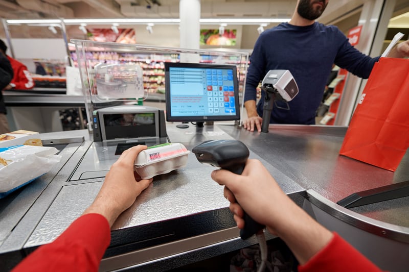 Mani effettuano la scansione di un prodotto alla cassa