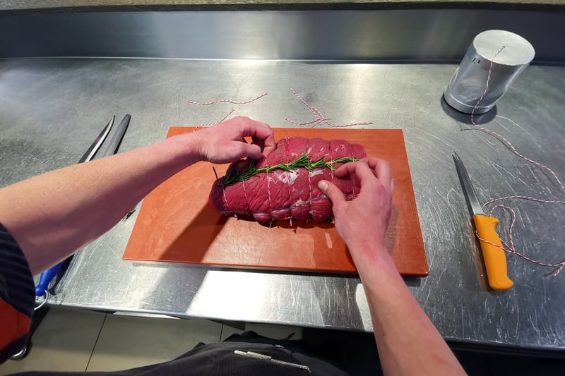 Mani preparano un pezzo di carne