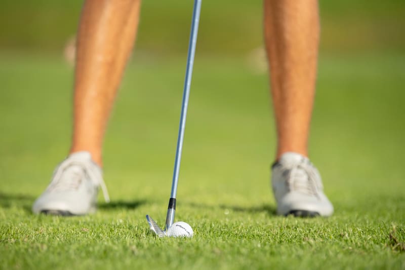 Golfer schlägt Ball aus Bunker
