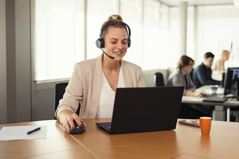 Frau mit Headset an rundem Tisch