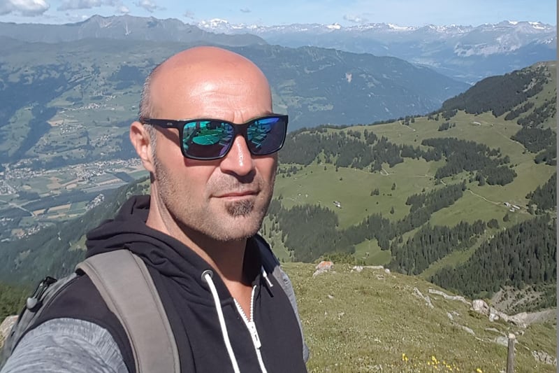 Uomo con occhiali che scatta un selfie