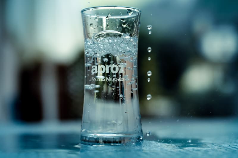 Un bicchiere di acqua con logo Aproz