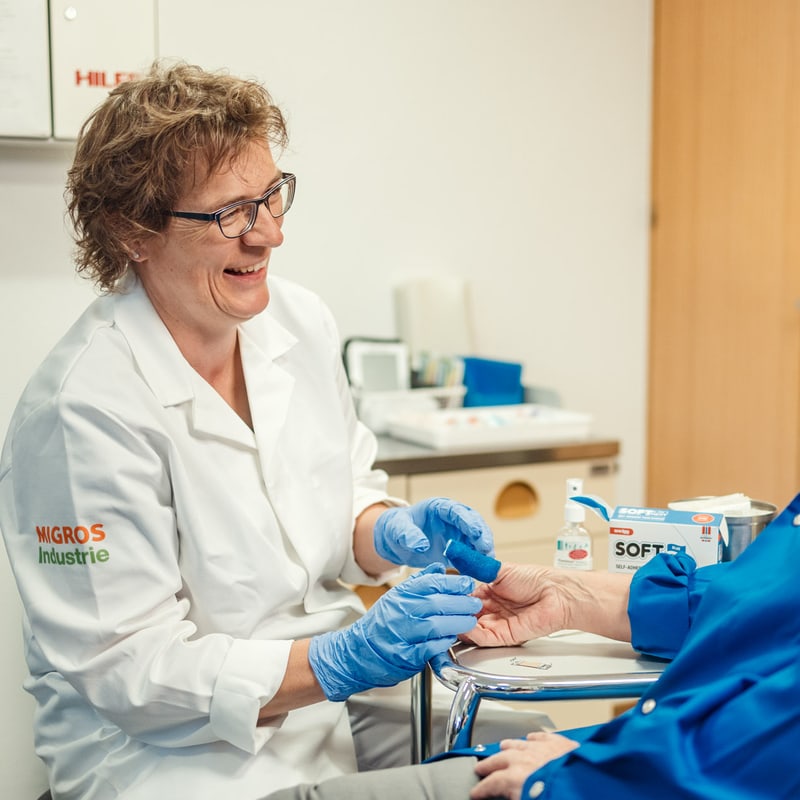 Sanitäterin verarztet Mitarbeiterin
