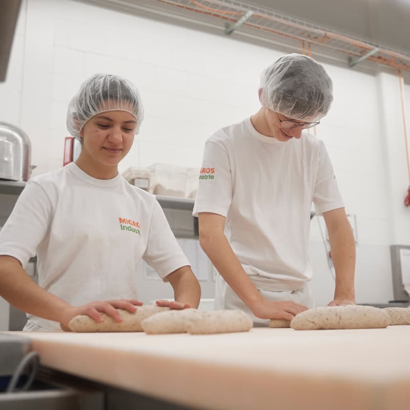 Mitarbeiter arbeiten und formen das Brot