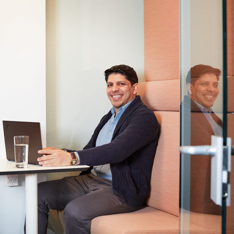 Mann sitzt im Büro auf einer bequemen Bank am Laptop