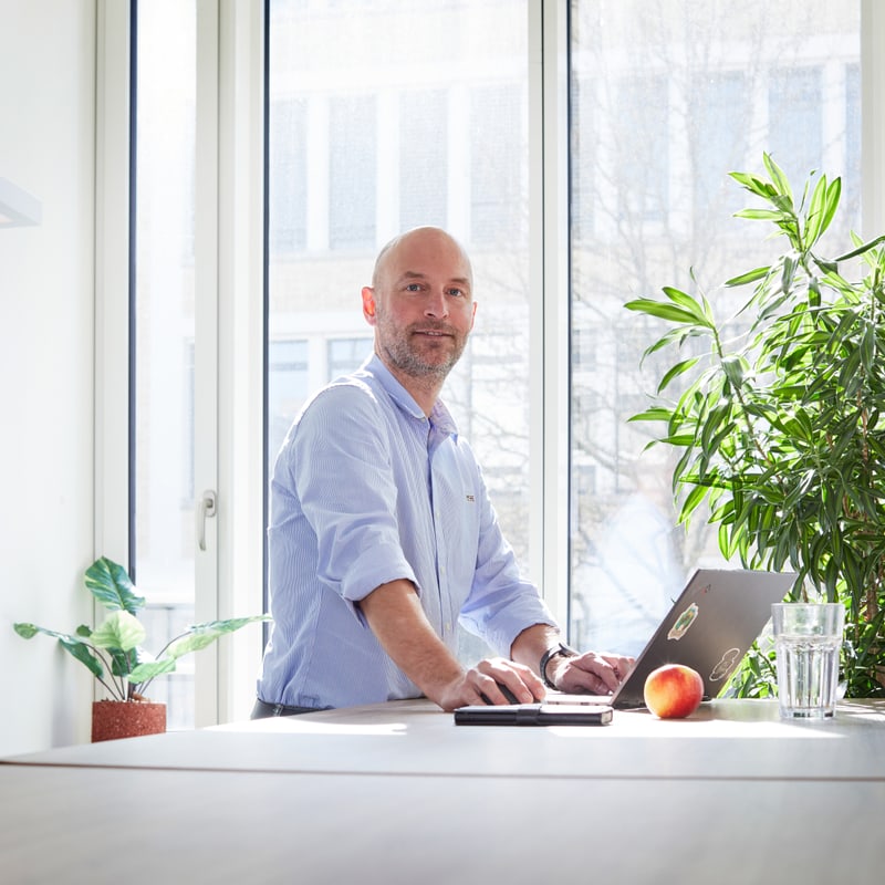 Ein Mann im Büro am Tisch und Laptop