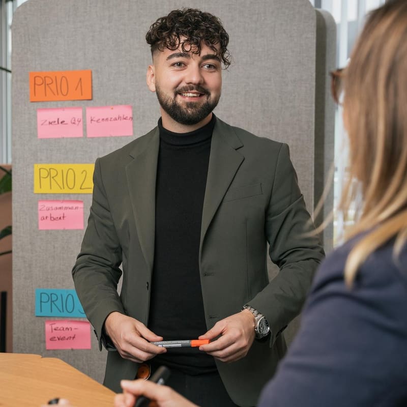 Ein Mitarbeiter des Backoffice ist in einem Gespräch mit einer Kollegin