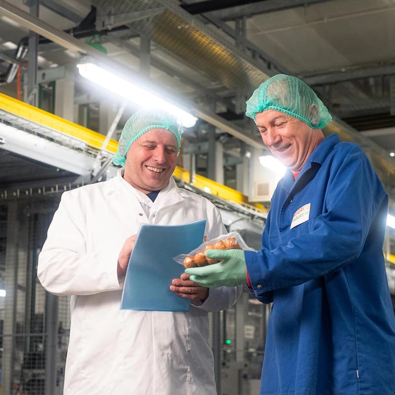 Mitarbeitende im Gespräch in der Produktion