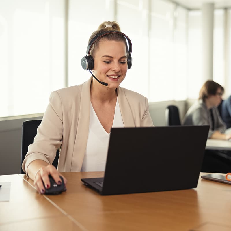 Frau mit Headset an rundem Tisch