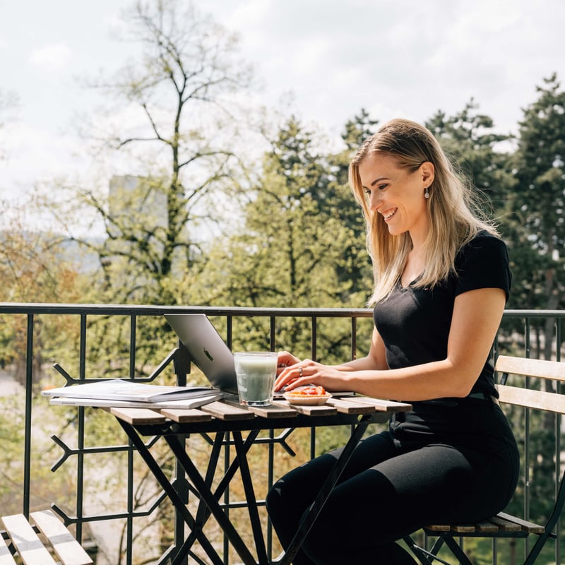 Migros Bank Alle Vorzüge im Überblick – Frau auf Balkon mit Laptop